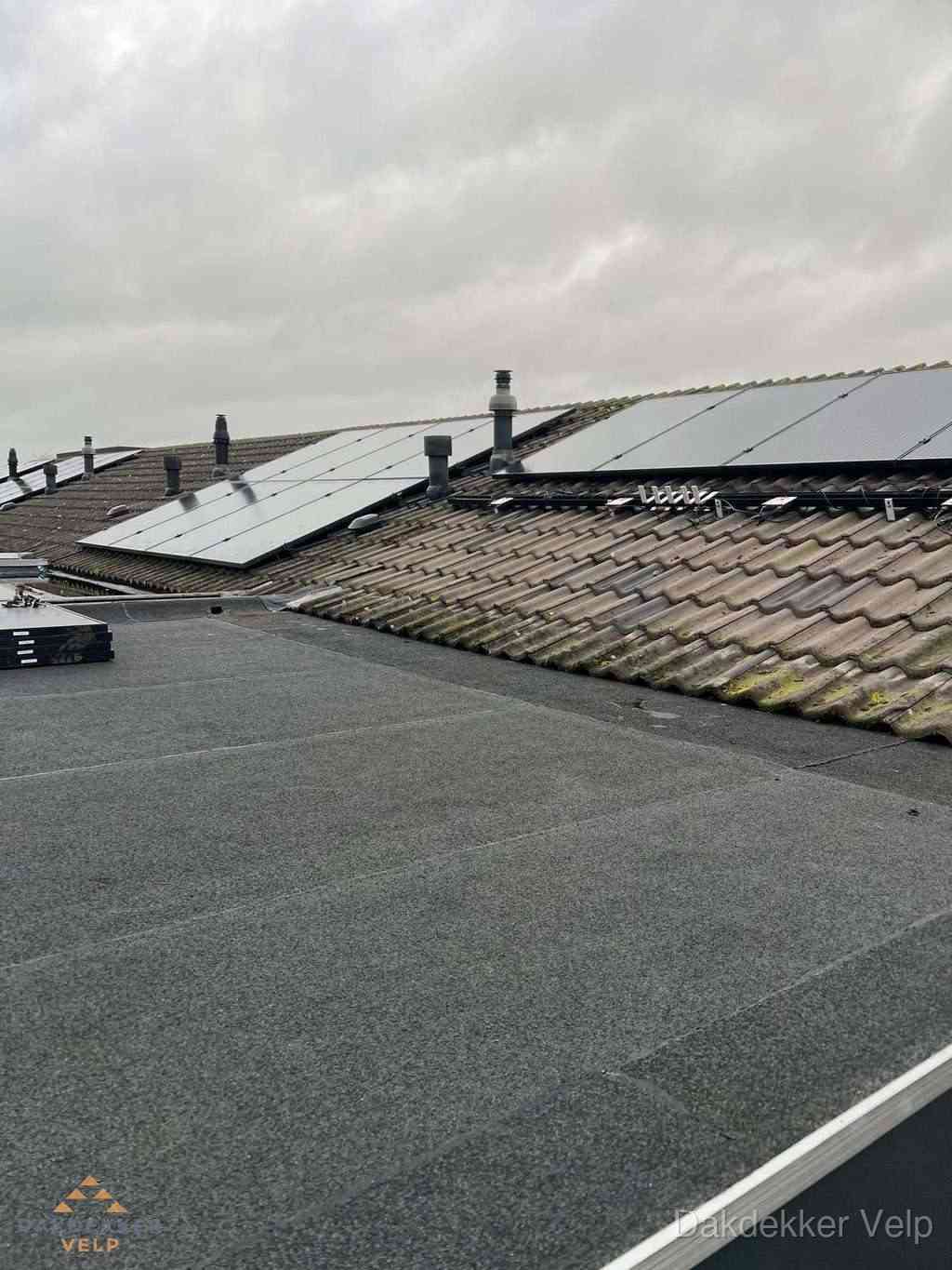 Plat dak inspectie met bitumen bedekking naast schuin pannendak in Velp