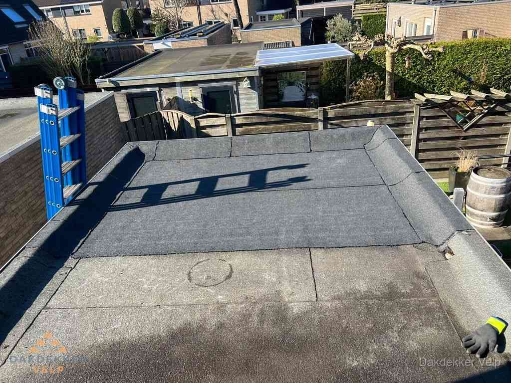 Dakdekker legt onderlaag op plat dak met houten constructie in Velp