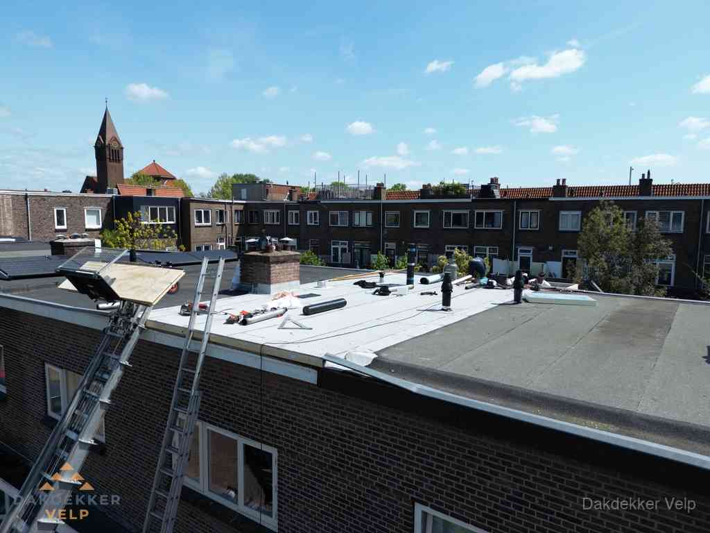 Dakdekkers aan het werk op plat dak in Velp