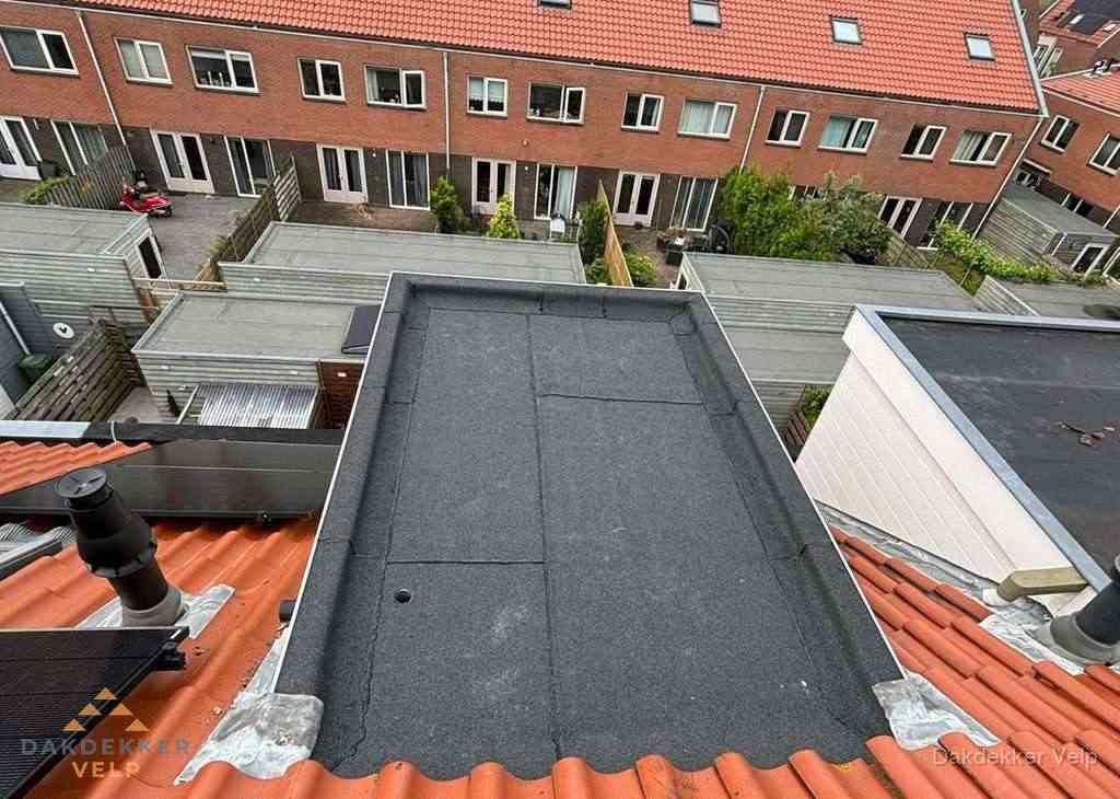 Plat dak met bitumen bedekking naast dakkapel in Velp