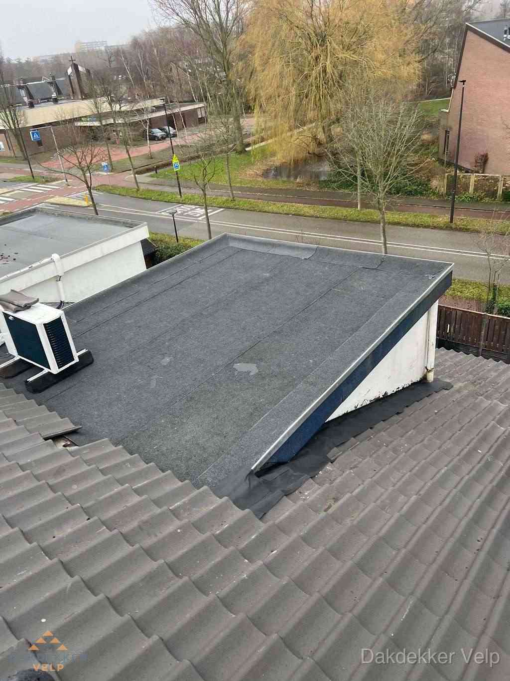 Plat dak met bitumen dakbedekking naast schuin pannendak in Velp