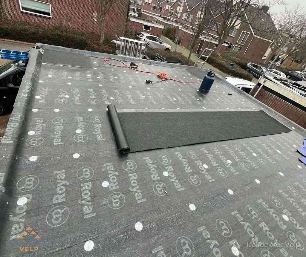 Dakdekker aan het werk met gasbrander op plat bitumen dak in Velp